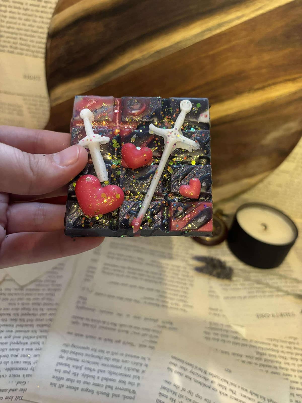 Black and red marbled wax melt block with red hearts and white swords on top 