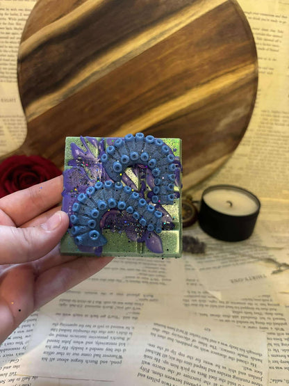 Green wax melt block with purple splatter and blue tentacles on top