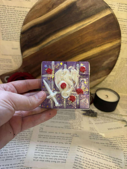 Dark purple glitter wax melt block with white dragon, white sword and red roses on top