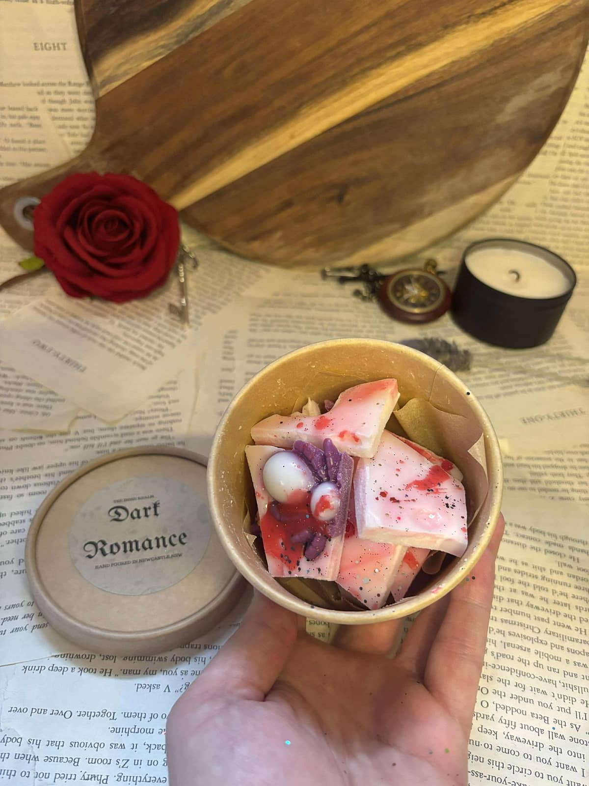 Red, white and purple marbled wax melt pieces in small circular cardboard tub