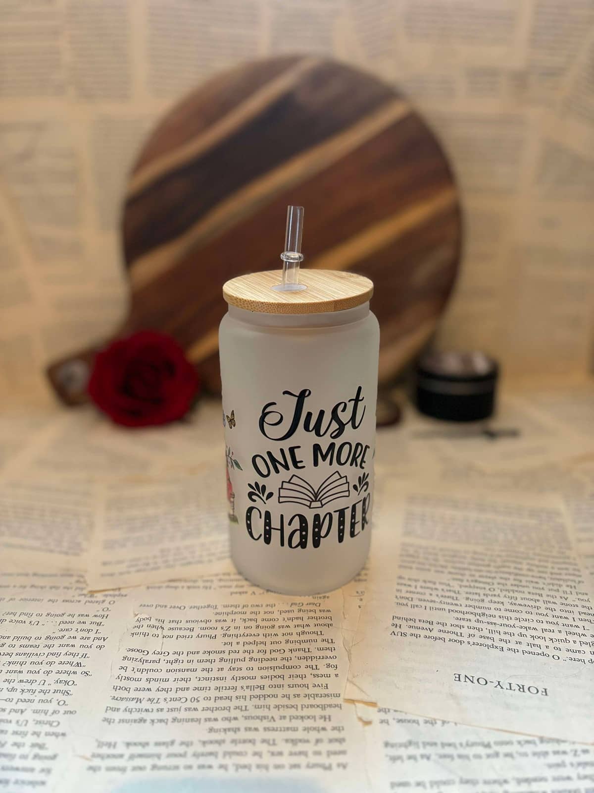 Just One More Chapter themed frosted glass cup featuring black graphic text on frosted glass, with wooden lid and clear straw