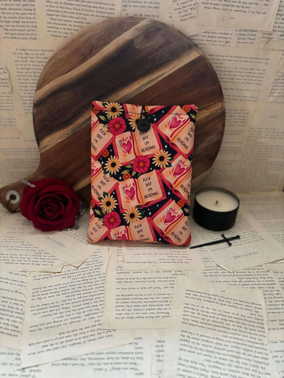 Kindle sleeve featuring red books, poppies and sunflowers on black fabric with graphic text "Fuck off I'm reading"