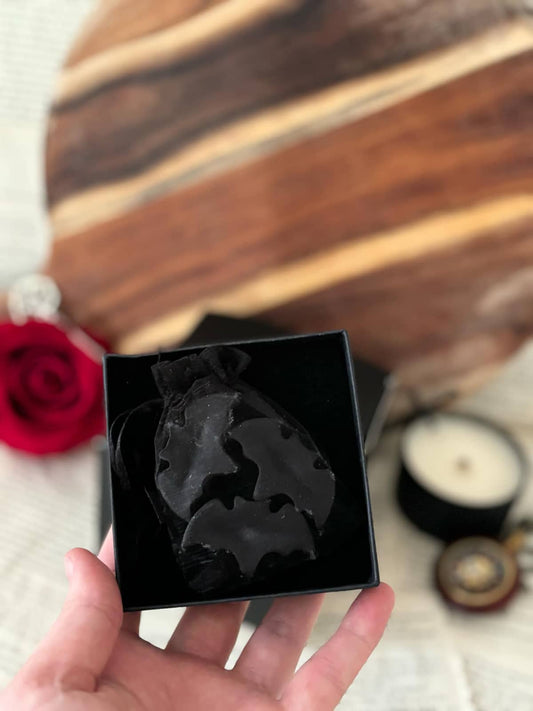 Three black bat-shaped wax melts in black box