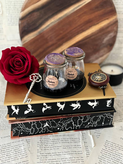 Spectral Bloom themed jewellery in a small potion bottle displayed on stack of books